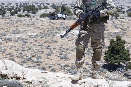 A Lebanon Hezbollah fighter carries his weapon as he stands in Khashaat, in the Qalamoun region after they advanced in the area May 15, 2015. REUTERS/Mohamed Azakir