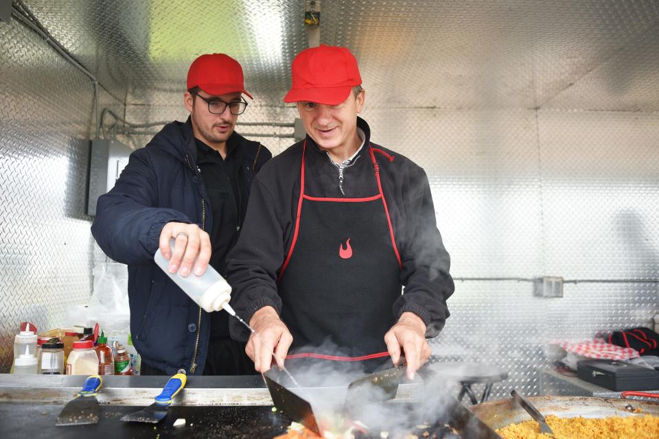 Borjan and Miron Jakasic make a chicken, rice and vegetables plate at the Boki food truck.