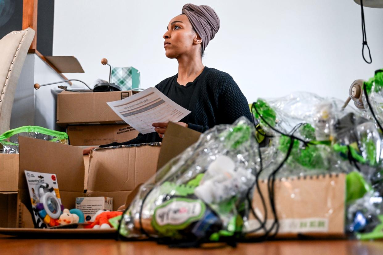 North Star Birthing Center intern Amina Mohamed works with owners Sharde' Burton and Domonique Brace to pack up supply bags for expecting mothers for their upcoming community baby shower on Wednesday, March 13, 2024, at Brace's home in Lansing.