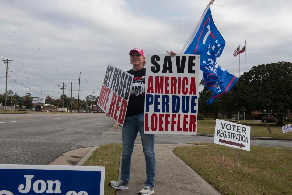 Karen Haythorn waves a Donald Trump flag on the sidewalk outside Chatham County Board of Elections Office at 1117 Eisenhower Drive on Monday during the first day of early voting.