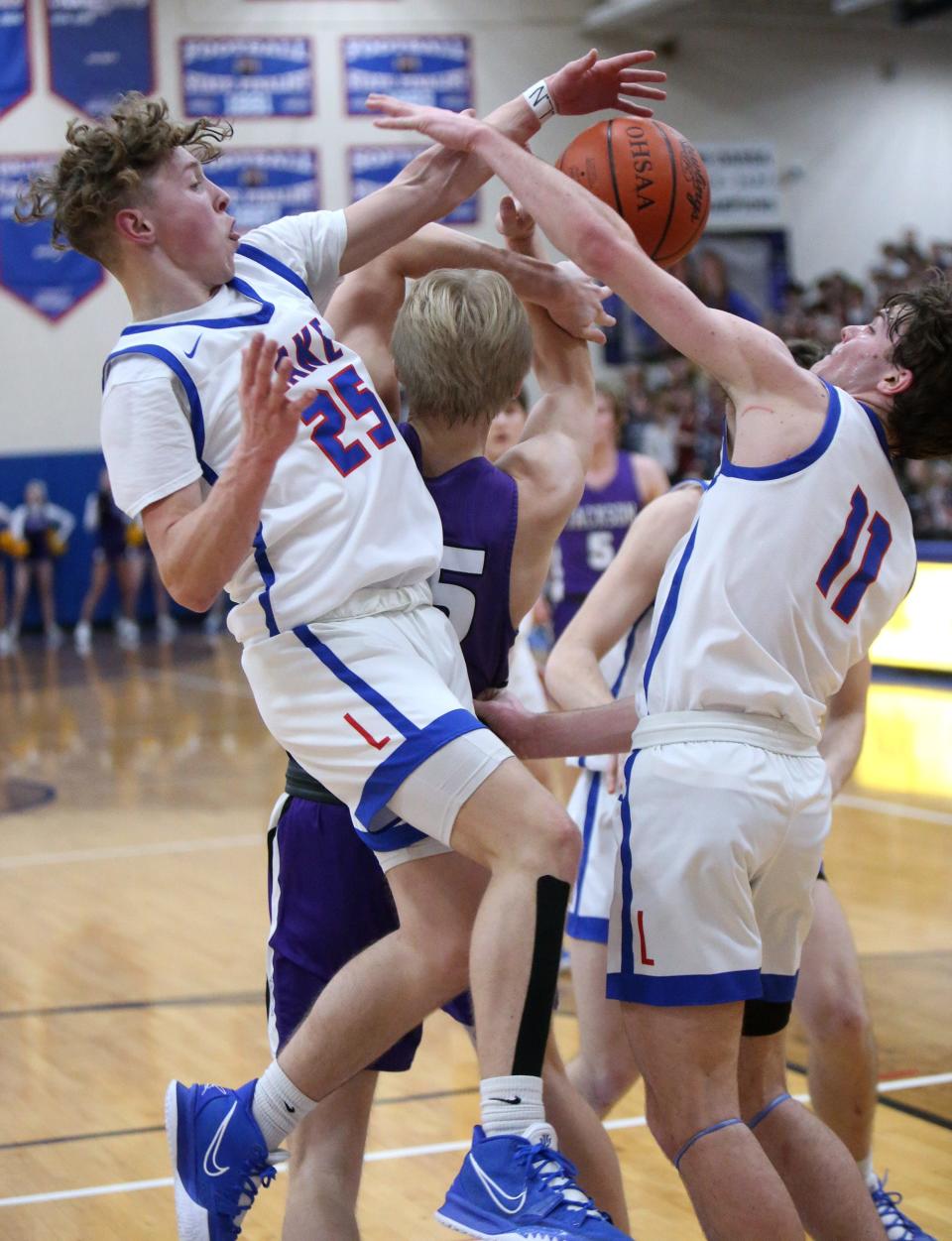 Chance Casenhiser, 25, and Camden Horning, 11, of Lake fights for a rebound with Owen Woolbert, center, of Jackson  during their game at Lake on Friday, Jan. 21, 2022.