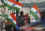 A roadside vendor carrying a child sells Indian flags on Independence Day in Hyderabad, India, Monday, Aug.15, 2022. The country is marking the 75th anniversary of its independence from British rule. (AP Photo/Mahesh Kumar A.)