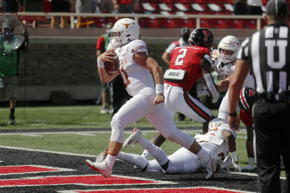 Texas quarterback Sam Ehlinger scores a touchdown during the first half of an NCAA college football game against Texas Tech, Saturday Sept. 26, 2020, in Lubbock, Texas. (AP Photo/Mark Rogers)