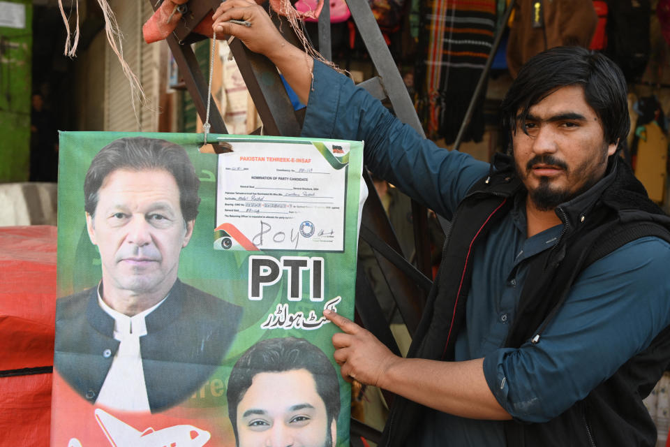 A vendor holds the poster with a portrait of Pakistan's jailed former prime minister Imran Khan at a market in Lahore, Feb. 9, 2024, a day after Pakistan's national elections. / Credit: AAMIR QURESHI/AFP/Getty