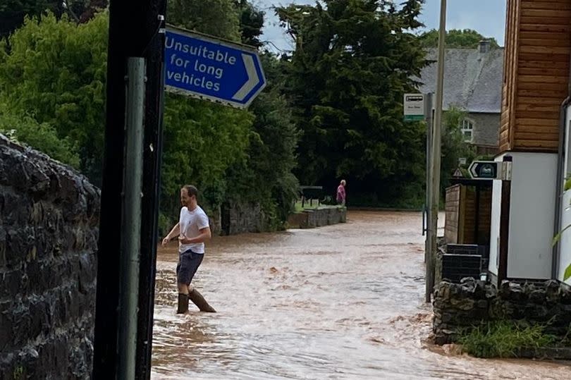 A river has burst its banks as heavy rain lashes the region