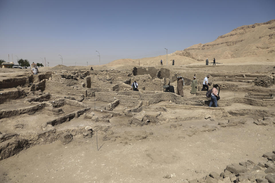 People stand in a 3,000-year-old lost city in Luxor province, Egypt, Saturday, April 10, 2021. The newly unearthed city is located between the temple of King Rameses III and the colossi of Amenhotep III on the west bank of the Nile in Luxor. The city continued to be used by Amenhotep III's grandson Tutankhamun, and then his successor King Ay. (AP Photo/Mohamed Elshahed)