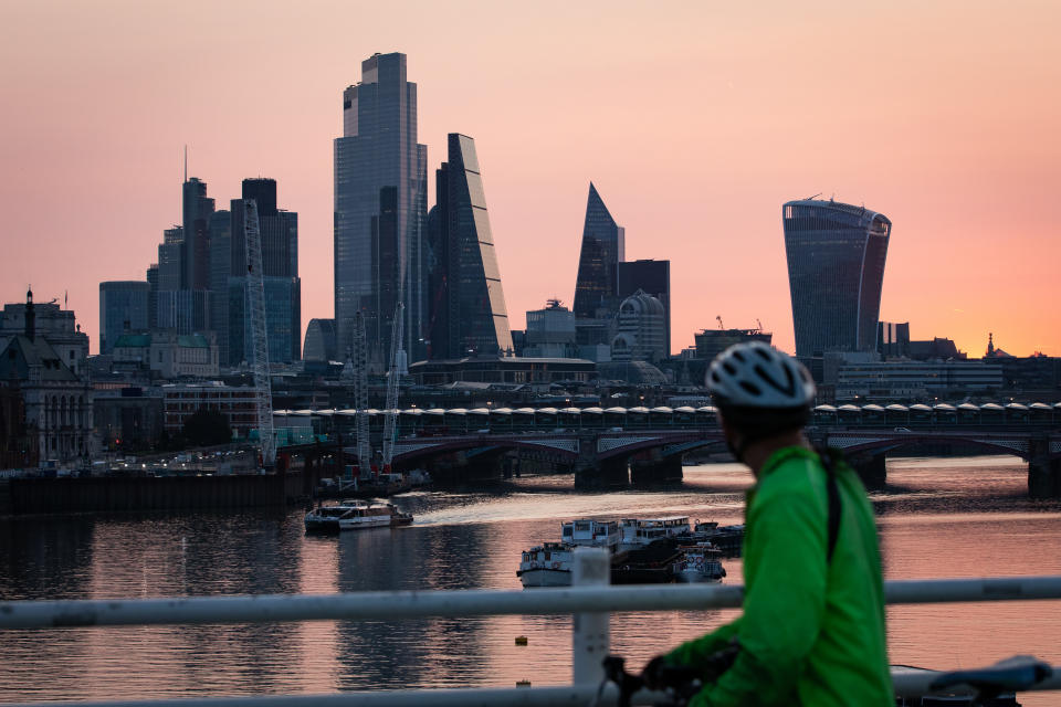 Early morning light bathes the skyscrapers of the City of London financial district, at the start of a week in which the UK is expected to bask in temperatures of more than 30C.