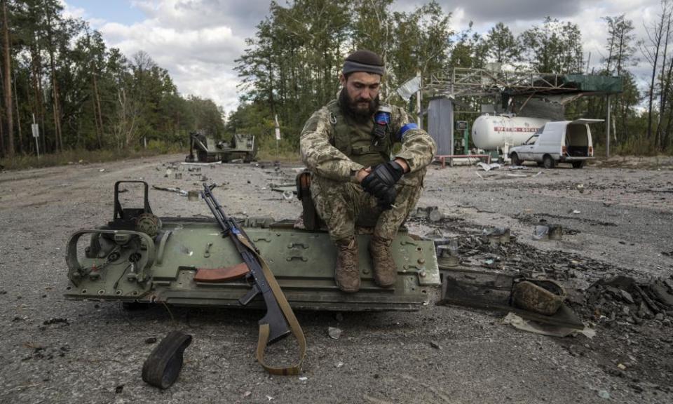 A Ukrainian serviceman smokes a cigarette after he finds and identifies a dead body of a comrade in recently recaptured town of Lyman, Ukraine.