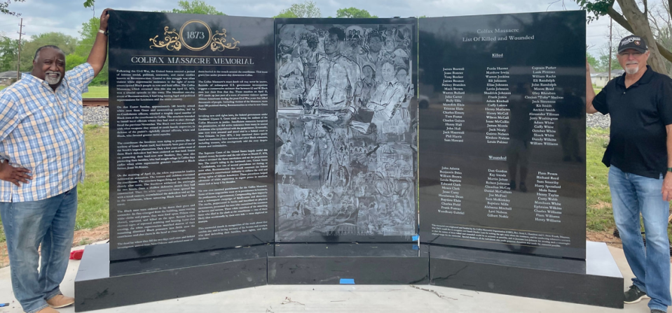 Avery Hamilton and Charles Dean Wood stand on either side of the Colfax Massacre Memorial monument, which honors the Black residents who were killed in the 1873 Colfax Massacre. (Credit: Colfax Memorial Organization)