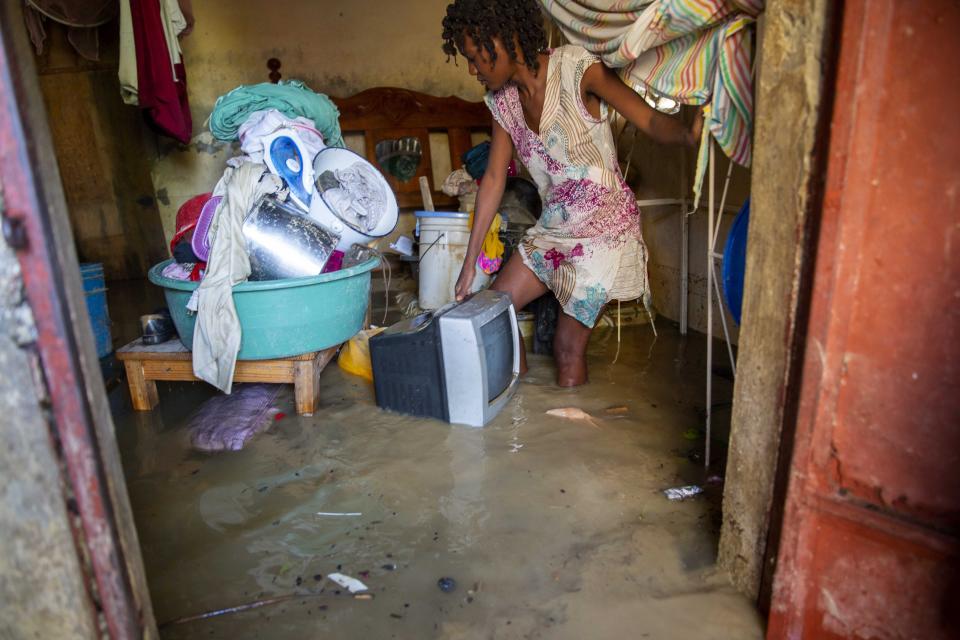 Lafaille Katia 28, removes salvage items from her flooded house the day after the passing of Tropical Storm Laura in Port-au-Prince, Haiti, Monday, Aug. 24, 2020. Forecasters fear Laura could become a major hurricane along the U.S. Gulf Coast. (AP Photo/Dieu Nalio Chery)