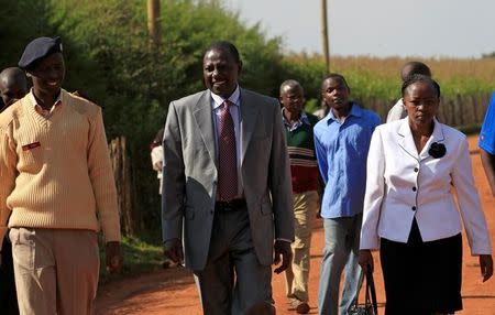 Kenya's Deputy President William Ruto and his wife Rachael are escorted as they walk to their home in Sugoi village near Eldoret, Kenya, in this photo taken August 4, 2010. Picture taken August 4, 2010. REUTERS/Thomas Mukoya