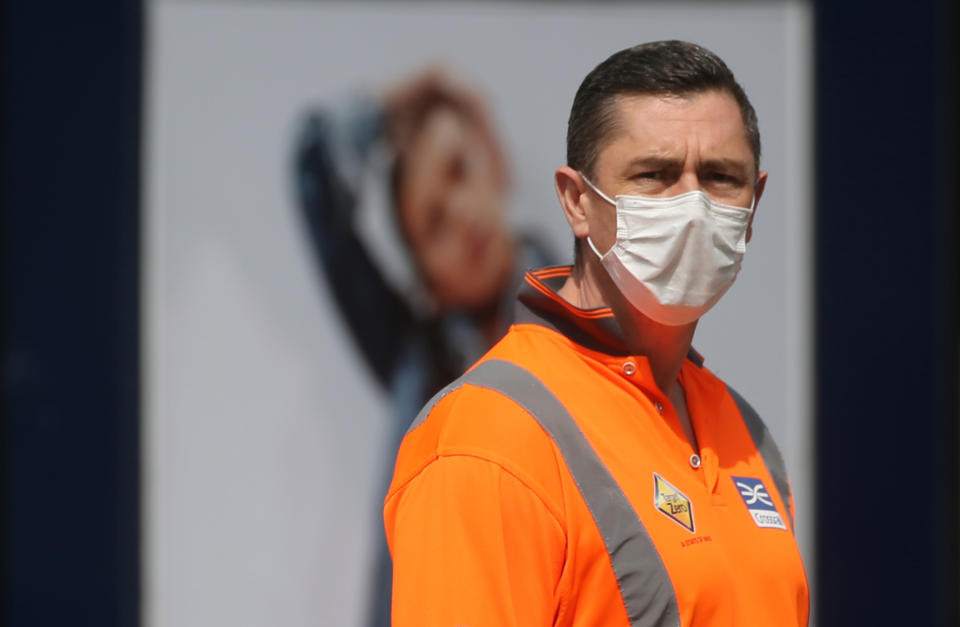 A Crossrail worker wearing a face mask by Piccadilly Circus in in central London, as the UK continues in lockdown to help curb the spread of the coronavirus. Issue date: Monday April 20, 2020.