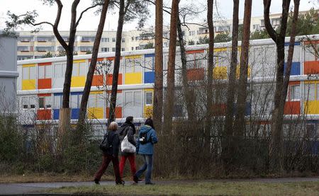 Pedestrians walk past a new refugee centre for housing asylum seekers in the Koepenick district of Berlin January 2, 2015. Six new container camps for refugees are to be built in the capital. REUTERS/Fabrizio Bensch