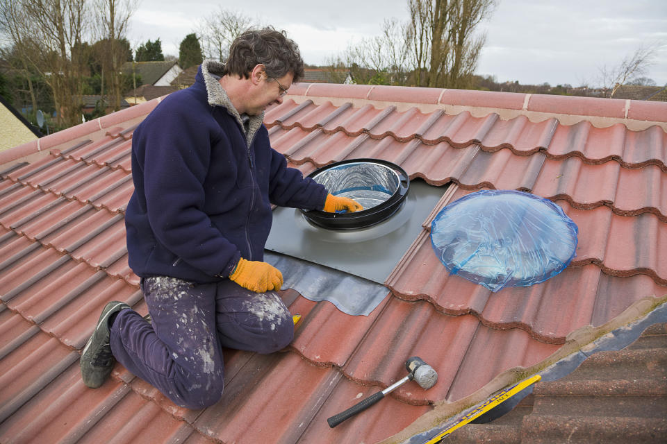 A man is installing a sun tunnel