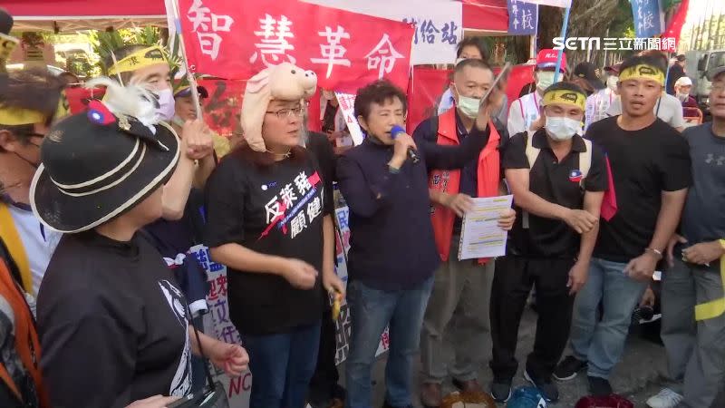 國民黨成員排排站，一起踩壞地上的豬撲滿。