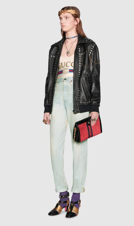 Gucci styled the ivory sparkling lyrca swimsuit with a pair of mom jeans, purple socks, black and gold heels, and a black biker jacket. (Photo: Gucci)