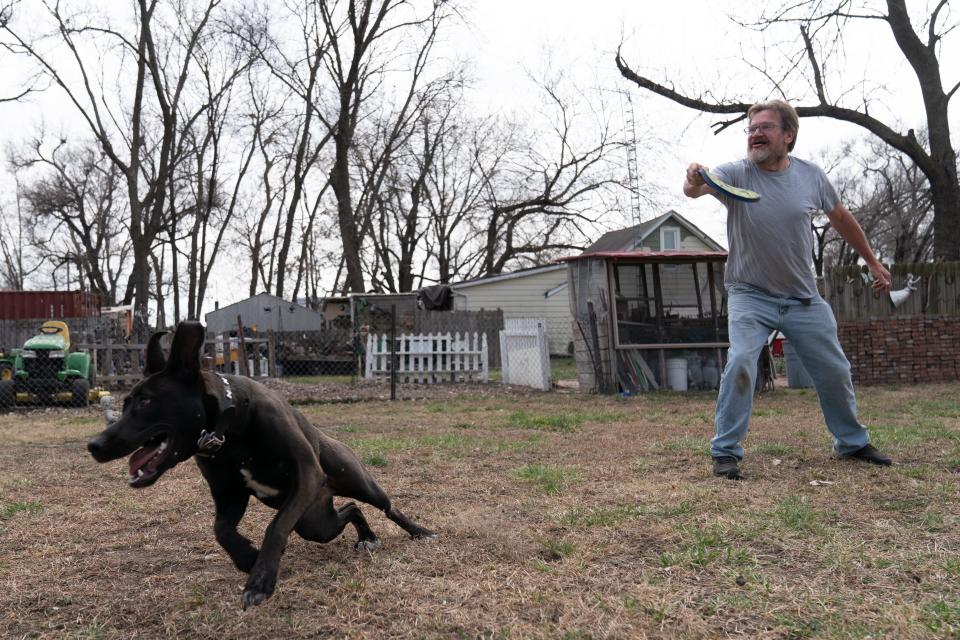 Before Don Beatty can pull back the frisbee, Lulu, his 1-year-old German Shepherd mix is off and running as they play catch in the backyard of their North Topeka home Monday.