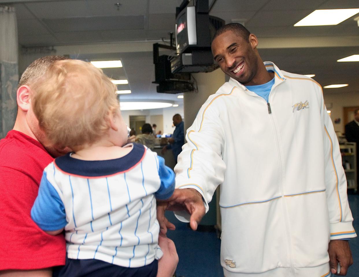 Los Angeles Lakers' Kobe Bryant smiles at 19-month-old Anne Raegan during a visit to  St. Jude Children's Research Hospital in Memphis, Tenn., Sunday April 3, 2005. The Lakers were in Memphis to play against the Memphis Grizzlies. Bryant is out with a leg injury.
