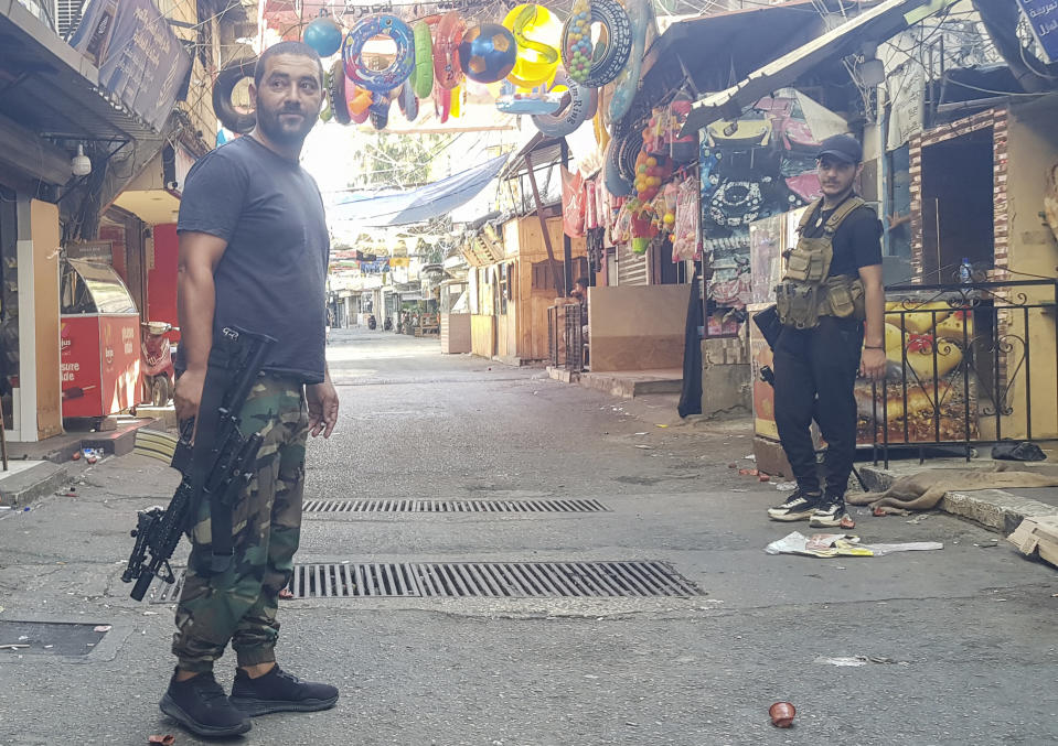 Members of Palestinian President Mahmoud Abbas' Fatah group stand guard during a third day of clashes that erupted with Islamist factions in the Palestinian refugee camp of Ein el-Hilweh near the southern port city of Sidon, Lebanon, Monday, July 31, 2023. (AP Photo/Mohammad Zaatari)