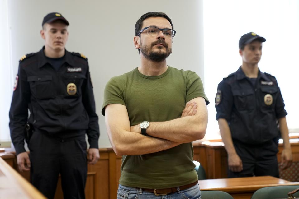 FILE - Ilya Yashin, Russian opposition activist and a municipal deputy of the Krasnoselsky district of Moscow, center, listens to the court's decision in Moscow, Russia, Wednesday, June 29, 2022. Yashin, 39, is one of the few prominent opposition figures that refused to leave Russia despite the unprecedented pressure the authorities have mounted on dissent in recent years. A sharp critic of the Kremlin, a vocal ally of imprisoned opposition leader Alexei Navalny and an uncompromising member of a Moscow municipal council, Yashin was arrested in June. (AP Photo/Alexander Zemlianichenko, File)