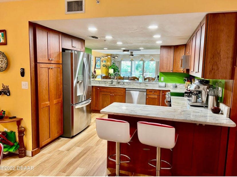 The updated and enlarged kitchen features gorgeous granite countertops, 25 rich, light cherry cabinets, two pantries and high-end appliances, including a double oven and a low-profile microwave.