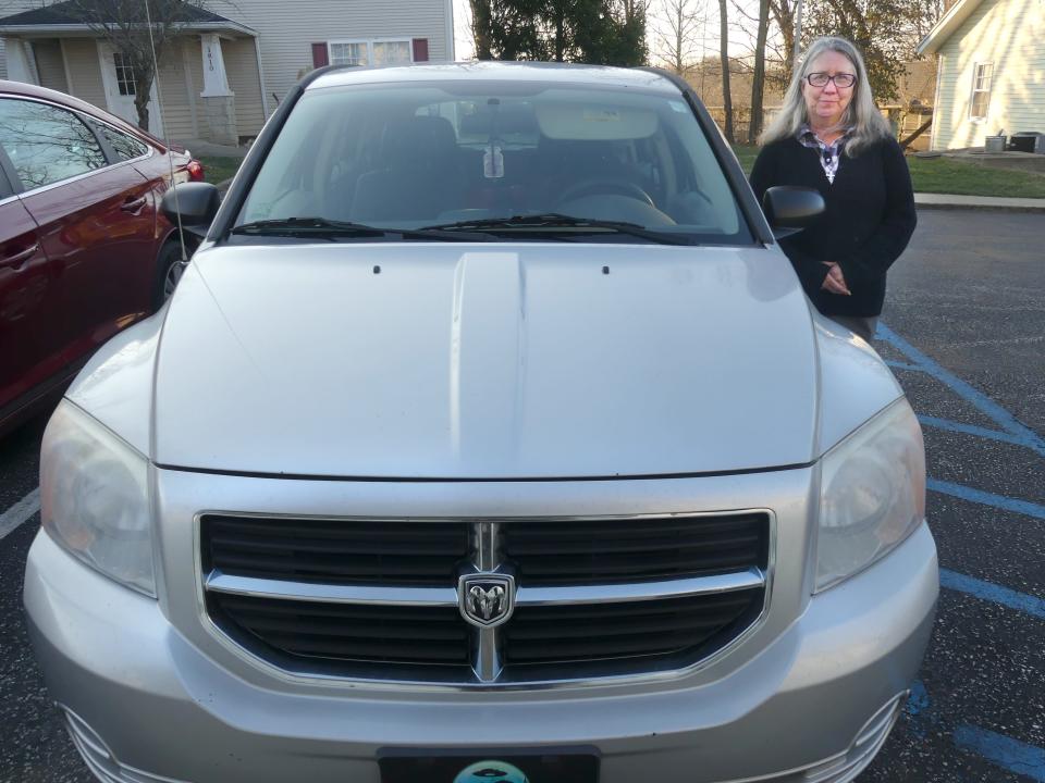 Heather Lake poses with her 2007 Dodge Caliber, which she uses to deliver coffee to Seminary Park's homeless community. Mechanical issues have Lake in need of a more reliable vehicle.