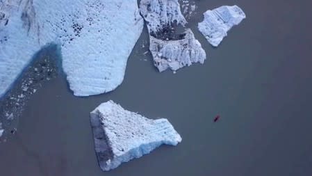 An aerial view shows people canoeing on the lake at the terminus of the Valdez Glacier in Alaska