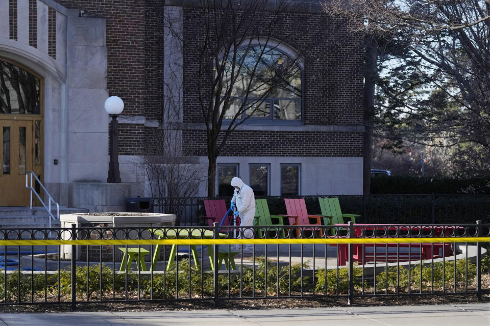 A worker cleans up outside Berkey Hall at Michigan State University, Tuesday, Feb. 14, 2023, in East Lansing, Mich. Police say the gunman who killed himself hours after fatally shooting three students at Michigan State University was 43-year-old Anthony McRae. Police also say five people who are in critical condition Tuesday are also students. (AP Photo/Carlos Osorio)