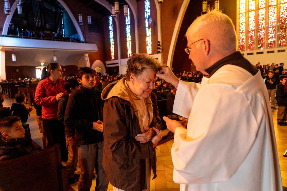 Maria Villalpondo, 81, receives ashes by altar server Jim Petersen during a Mass on Ash Wednesday at SS. Simon & Jude Cathedral in Phoenix on Feb. 22, 2023.