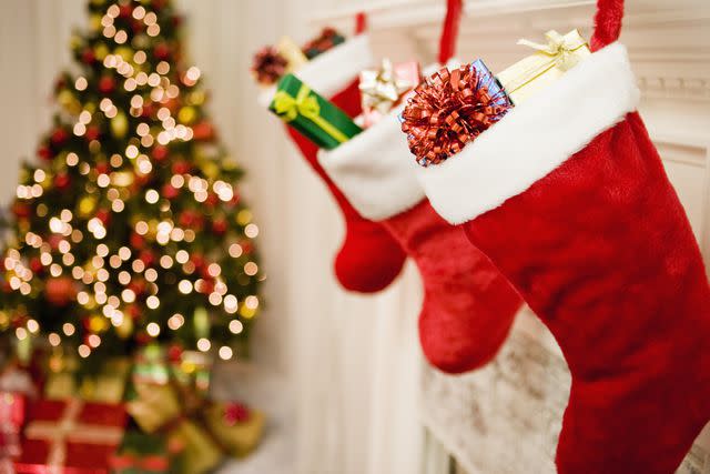 Jose Luis Pelaez/Creative Images/Getty Images Stock image of Christmas stockings hanging on mantle with Christmas tree in the background