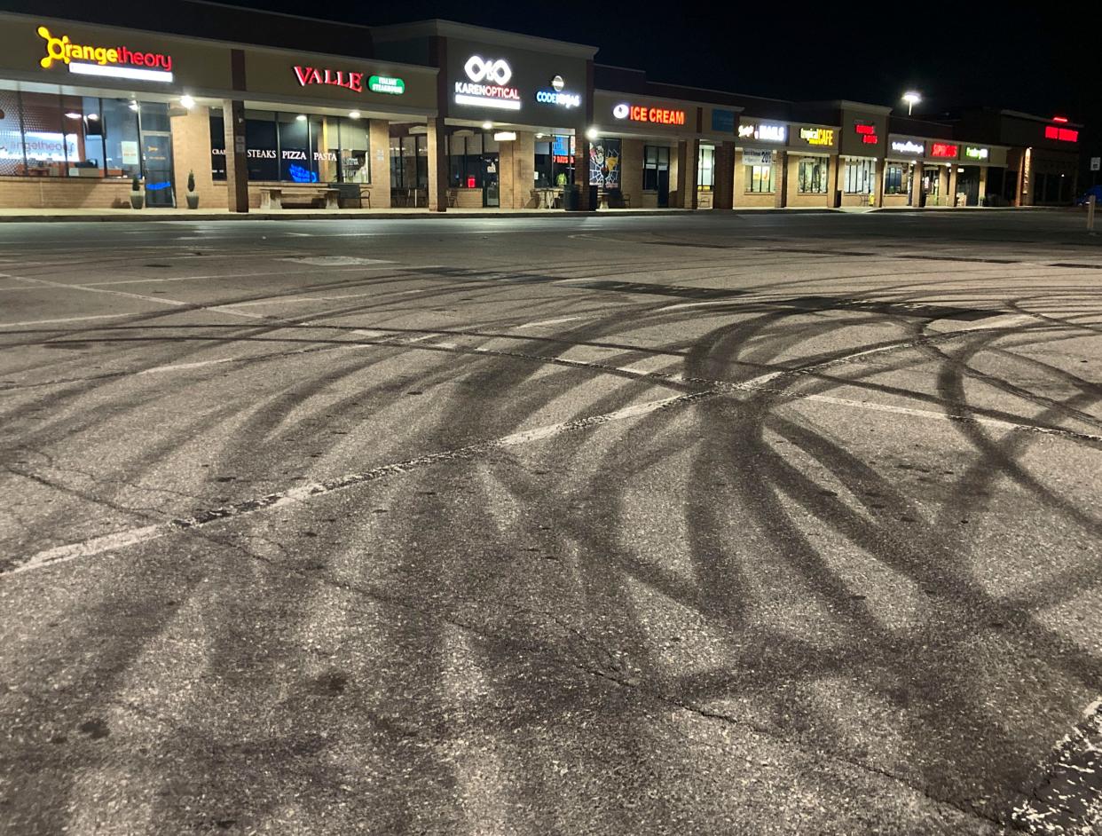 Donuts and tire burnout marks are left in the parking lot of the Pike Creek Shopping Center after a car gathering was broken up near midnight, Saturday, August 26, 2023.