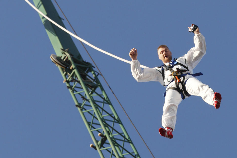 Former England cricketer Andrew "Freddie" Flintoff dangles from a rope as he attempts to break the world record for the highest reverse bungee jump in North London on March 19, 2012. Flintoff was attempting to set twelve Guinness World Records in 12 hours to raise money for the Sport Relief charity. AFP PHOTO / JUSTIN TALLIS (Photo credit should read JUSTIN TALLIS/AFP/Getty Images)