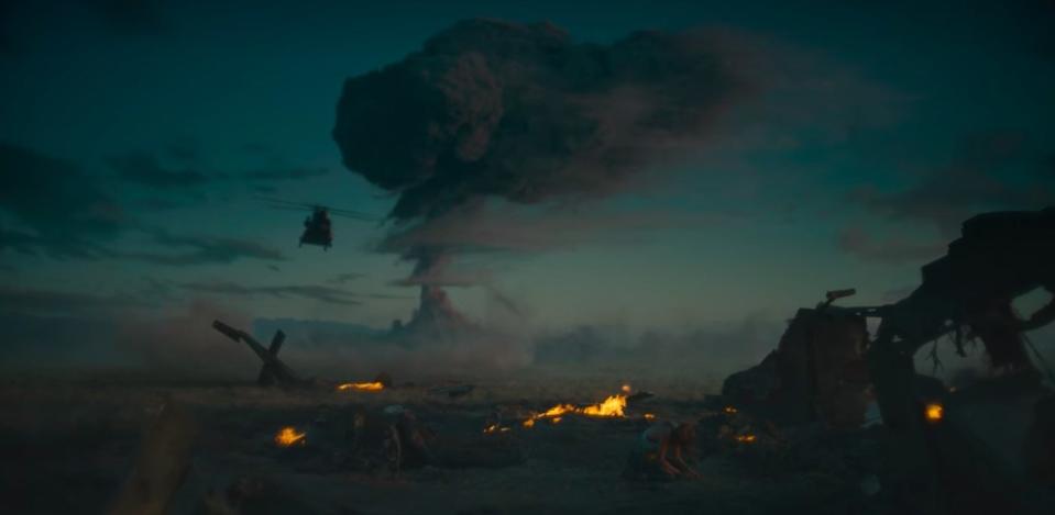 Kate sitting on the ground crying with a mushroom cloud in the background in "Army of the Dead"