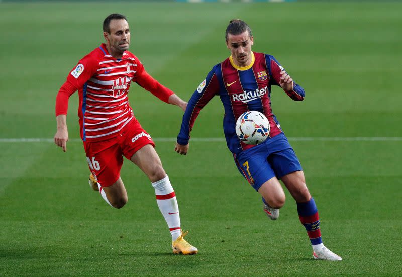 Víctor Díaz del Granada y Antoine Griezmann del Barcelona disputan el balón en un partido por La Liga, en el estadio Camp Nou, en Barcelona, Cataluña, España