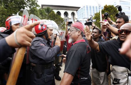 A supporter (C, on right) of Malaysian opposition leader Anwar Ibrahim clashes with a policeman outside court in Putrajaya February 10, 2015. REUTERS/Olivia Harris