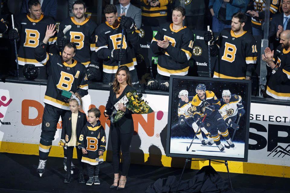 Boston Bruins' David Krejci (46) waves as he stands with his family during a ceremony to honor his 1000th game with the team before an NHL hockey game against the Ottawa Senators, Monday, Feb. 20, 2023, in Boston. (AP Photo/Michael Dwyer)