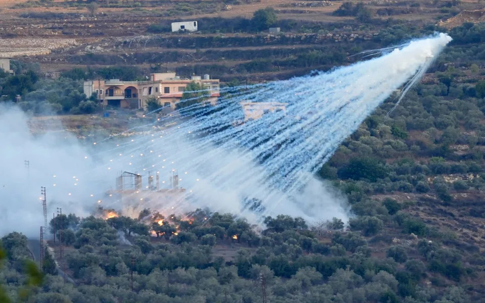 A shell from Israeli artillery explodes over a house in al-Bustan, a Lebanese border