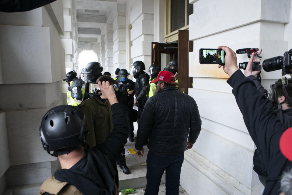 FILE - In this Jan. 6, 2021, file photo people record as Capitol police officers push back violent insurrectionists loyal to President Donald Trump U.S. Capitol in Washington. (AP Photo/Jose Luis Magana, File)
