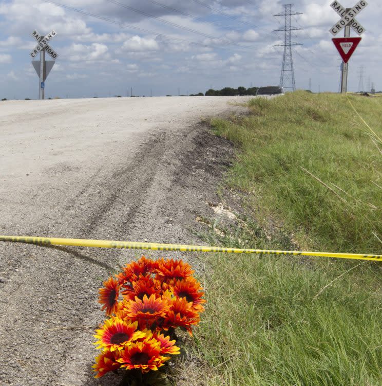 Flowers sit next to police tape at the site of Saturday's hot air balloon crash near Lockhart, Texas, Sunday, July 31, 2016. (Jessalyn Tamez/Austin American-Statesman via AP)