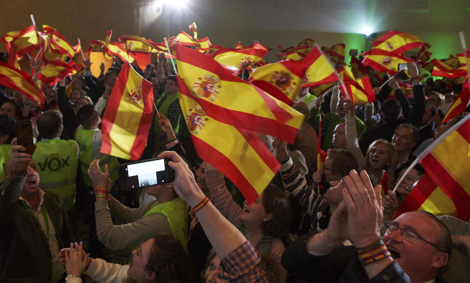 In this Sunday, Dec. 2, 2018 photo, supporters of Spain's far-right Vox party, wave Spanish flags as they celebrate the results during regional elections in Andalusia, in Seville, Spain. The Socialists won just 33 seats in the Andalusia legislature, compared to 47 in 2015. The party could lose control of Spain's most populated region for the first time in 36 years if parties on the right can agree to form a government. The anti-immigrant, extreme right Vox party won 12 seats - its first in any Spanish legislative body. (AP Photo/Gogo Lobato)