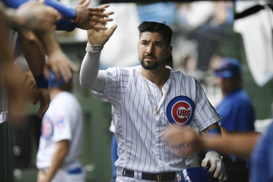 Chicago Cubs' Nicholas Castellanos celebrates with teammates in the dugout after scoring on a passed ball by St. Louis Cardinals catcher Yadier Molina during the first inning of a baseball game Sunday, Sept. 22, 2019, in Chicago. (AP Photo/Paul Beaty)