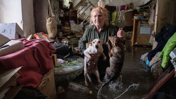 PHOTO: A resident holds her pets, Tsatsa and Chunya, as she stands inside her house that was flooded after the Kakhovka dam blew up overnight, in Kherson, Ukraine, June 6, 2023. (Evgeniy Maloletka/AP)