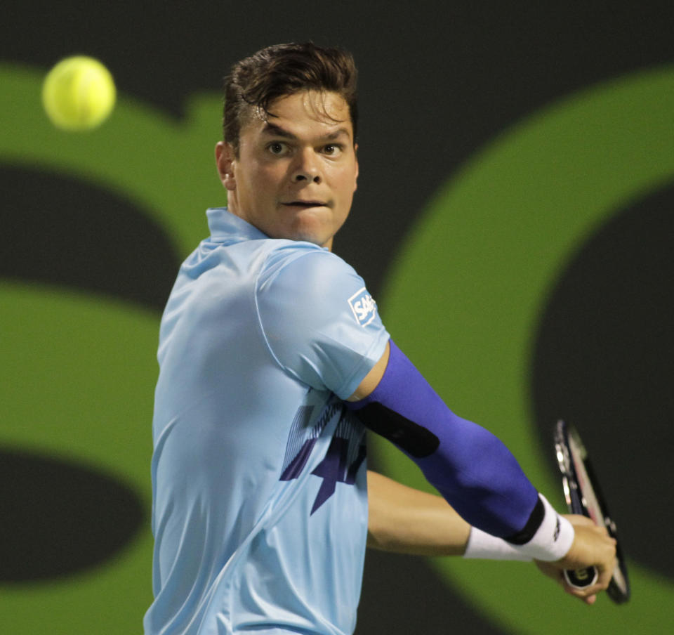 Milos Raonic, of Canada, returns the ball to Rafael Nadal, of Spain, during the Sony Open tennis tournament, Thursday, March 27, 2014, in Key Biscayne, Fla. (AP Photo/Luis M. Alvarez)