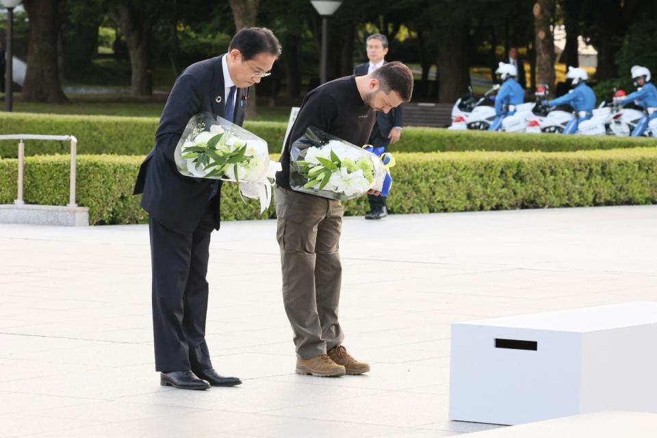 日本首相岸田文雄（左）與烏克蘭總統澤倫斯基（右）一同向和平紀念公園內的原爆慰靈碑獻花悼念。路透社