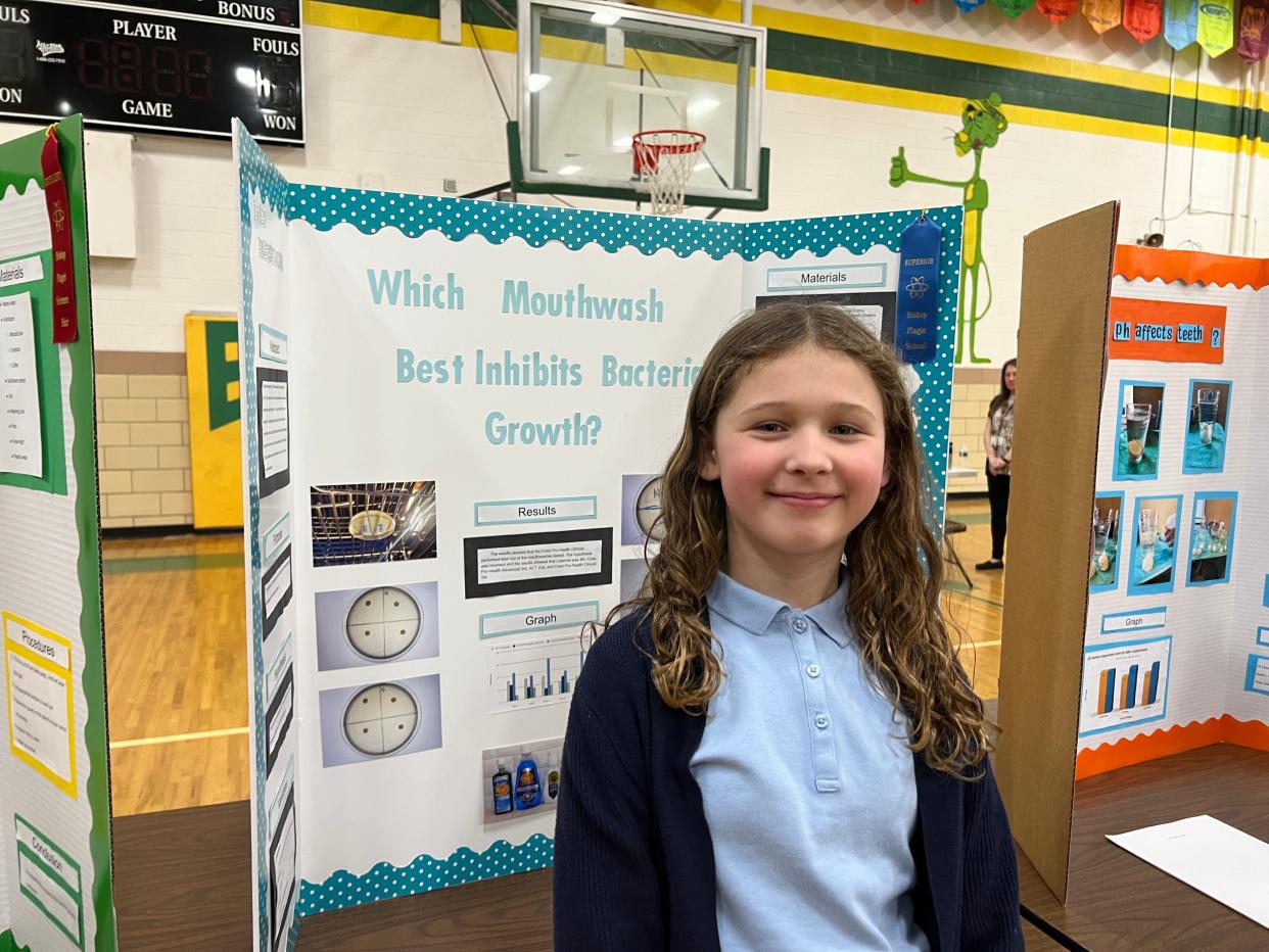 Seventh grader Lucy Thompson with her science fair board.