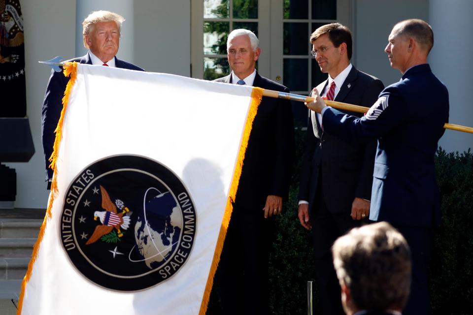 In this Aug. 29, 2019, file photo, President Donald Trump, left, watches with Vice President Mike Pence and Defense Secretary Mark Esper as the flag for U.S. space Command is unfurled as Trump announces the establishment of the U.S. Space Command in the Rose Garden of the White House in Washington. President Joe Biden has decided to keep U.S. Space Command headquarters in Colorado, overturning a last-ditch decision by the Trump administration to move it to Alabama and ending months of politically fueled debate, according to senior U.S. officials.