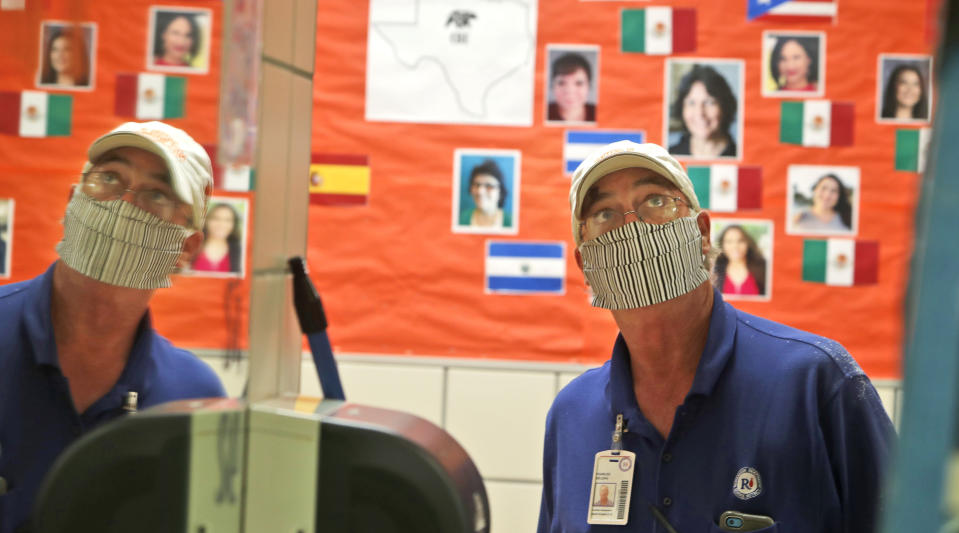 Charles DeLong, a Richardson Independent School District facility services worker, watches the installation of a plexiglass barrier in the student's restroom at Bukhair Elementary School in Dallas, Wednesday, July 15, 2020. (AP Photo/LM Otero)