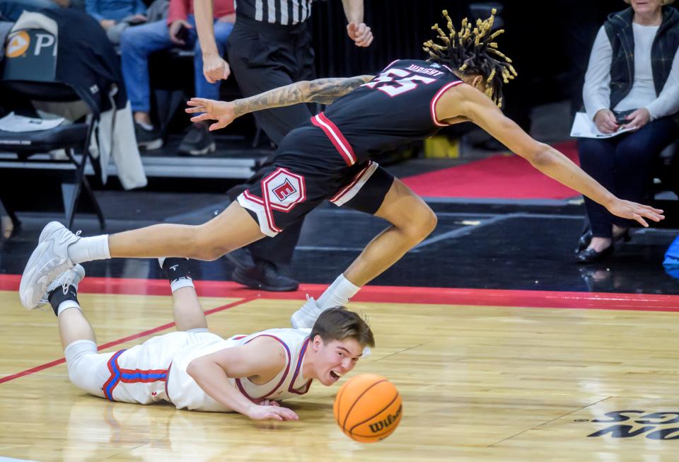 Bradley's Cade Hardtke, bottom, and SIU-Edwardsville's Lamar Wright fall over each other while chasing a loose ball in the first half of their nonconference basketball game Thursday, Dec. 21, 2023 at Carver Arena. The Braves defeated the Cougars 75-64.