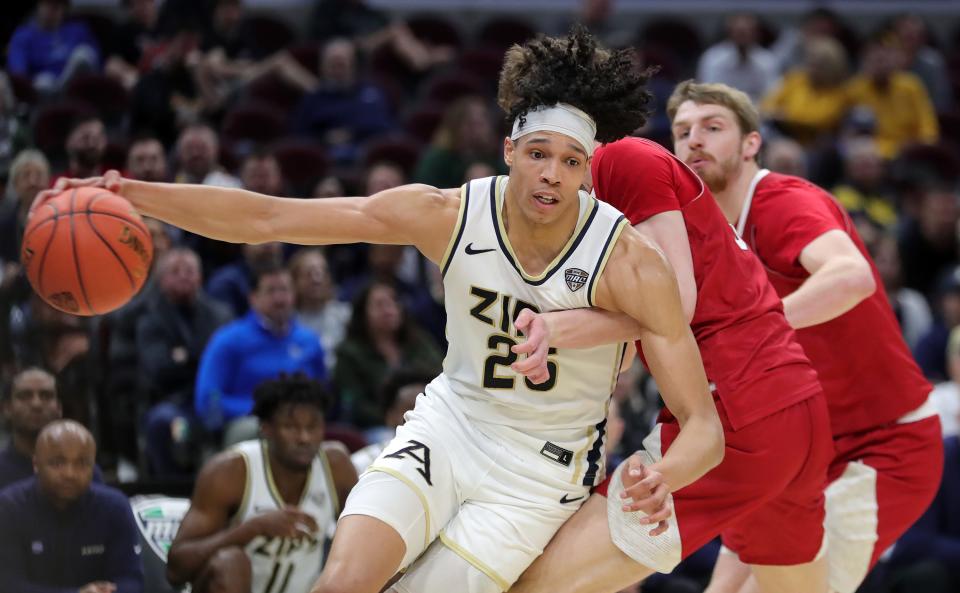 Akron Zips forward Enrique Freeman (25) drives to the basket against a Miami (OH) Redhawks defender during the second half of an NCAA college basketball game in the quarterfinals of the Mid-American Conference Tournament at Rocket Mortgage FieldHouse, Thursday, March 14, 2024, in Cleveland, Ohio.