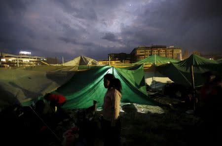 A girl stands outside her makeshift shelter at an open ground after an earthquake in Kathmandu, Nepal April 26, 2015. REUTERS/Adnan Abidi